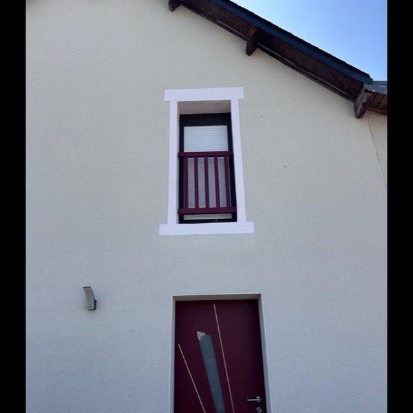 Façade blanche et encadrements repris autour de la porte