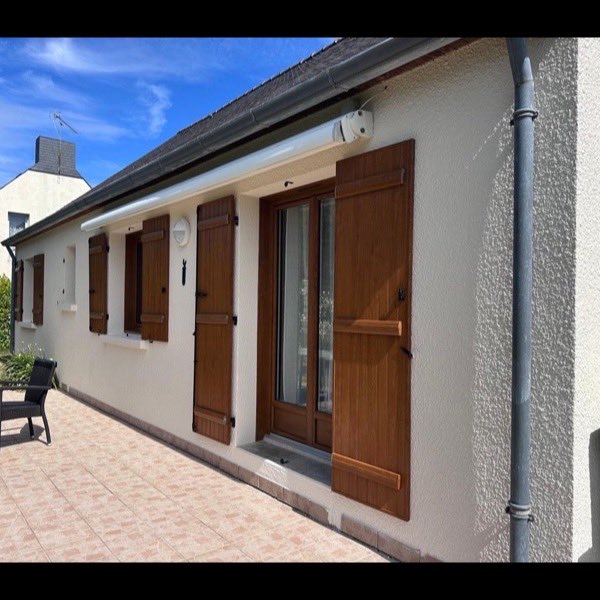 Façade rénovée, volets bois et terrasse pavée