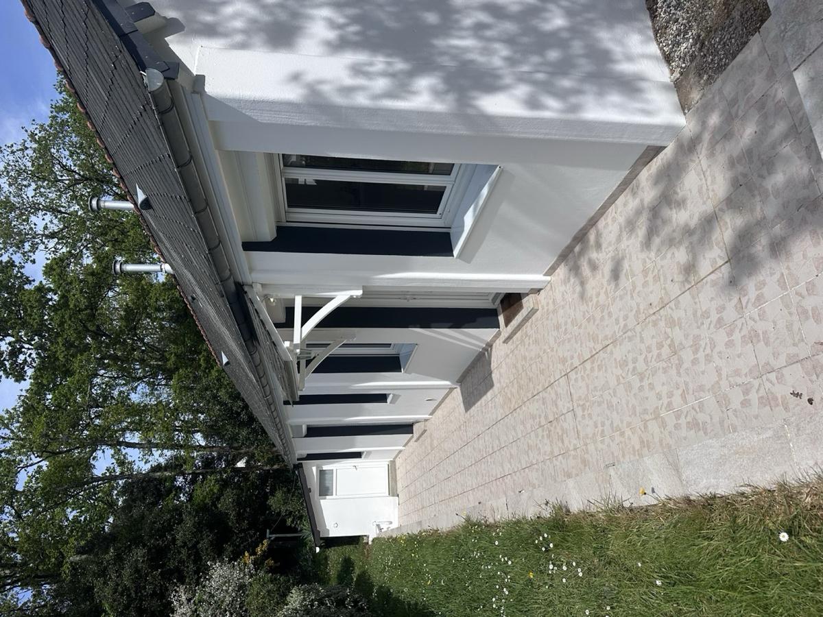 Longère rénovée, façade blanche et volets bleu marine